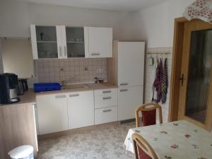 a kitchen with white cabinets and a table in it at Apartments mit 2 Schlafzimmern in Dresden