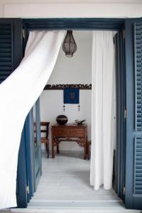 una porta aperta con tende bianche e un tavolo di Quartara Boutique Hotel a Panarea