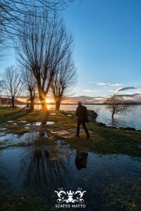 Un uomo che cammina vicino a una pozzanghera d'acqua vicino a un lago di Hotel Italia & Lombardi a Montefiascone