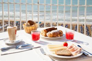 stolik z dwoma talerzami jedzenia i plaża w obiekcie Regent's Hotel w mieście Lido di Jesolo +37 zdjęć