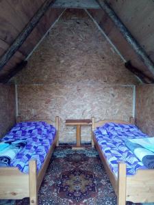 two beds in a room with a stone wall at Eco Village Goles in Kolašin