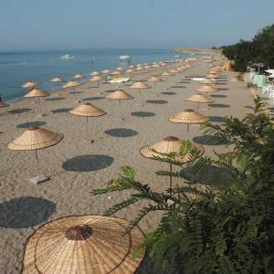 a bunch of umbrellas on a beach with the ocean at Silivri Park Hotel in Silivri