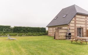 a brick building with a picnic table in a yard at Les Champs De La Mer in Auberville-la-Renault