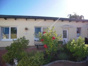 a white house with flowers in front of it at Ferienwohnung Achterwasser in Ueckeritz