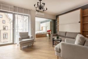 グダニスクにあるVIU Indigo Apartmentsのリビングルーム(ソファ、椅子付)、ベッドルーム1室が備わります。