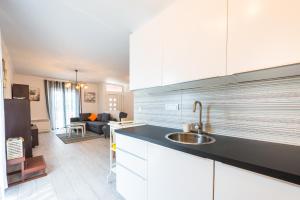 eine Küche mit weißen Schränken und ein Wohnzimmer in der Unterkunft Apartment Semes in Cavtat