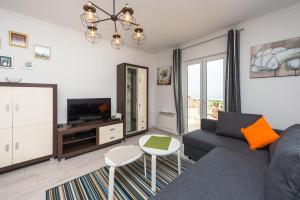 sala de estar con sofá y TV en Apartment Semes, en Cavtat