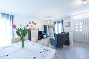 una sala de estar con una mesa con un jarrón de flores. en Apartment Semes, en Cavtat