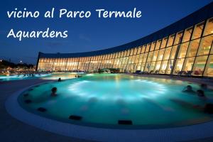 - un bâtiment avec une grande piscine bleue en face dans l'établissement Ai Due Pini B&B, à Pescantina
