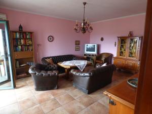 a living room with leather furniture and a table at Nestos, Meer und Berge - Griechenland mal anders in Zarkadhiá