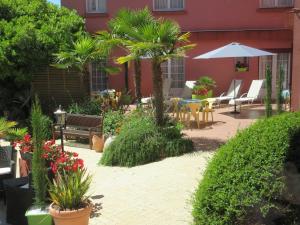 a patio with a table and chairs and plants at Le Trianon in &Eacute;tel