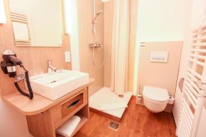 uma casa de banho com um lavatório e um WC em Hotel Ohlendorfs Gasthaus em Hermannsburg