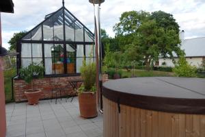 a glass gazebo in a garden with plants at Villa Gina Österlen in Sankt Olof