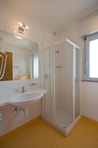 y baño con ducha y lavamanos. en Residence Torre di Noe, en Bibione