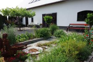 einen Garten vor einem weißen Gebäude mit einer Statue in der Unterkunft Villa Gina Österlen in Sankt Olof