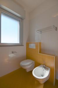 baño con aseo y lavabo y ventana en Residence Torre di Noe, en Bibione