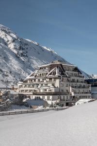 奧伯古格爾的住宿－阿爾盆蘭德酒店，山上的雪中一座白色的大建筑
