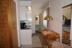 a kitchen with a table and a dining room at Paradies 503 in Arosa +9 photos