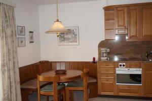 アローザにあるParadies 506のキッチン(小さなテーブル、テーブル、椅子付)