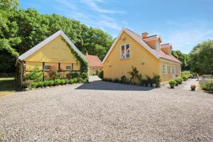 ein großes gelbes Haus mit Kieseinfahrt in der Unterkunft Amalies Annex in Sorø