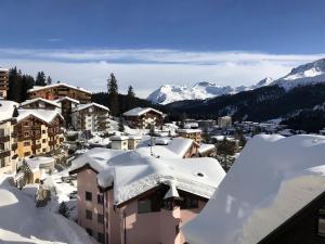 eine Stadt mit Schnee und Bergen im Hintergrund in der Unterkunft La Cabana 5 Arosa in Arosa