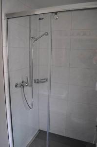 a shower with a glass door in a bathroom at Paradies 210 in Arosa