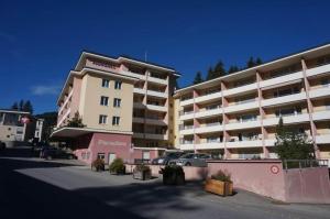 a large apartment building with cars parked in a parking lot at Paradies 503 in Arosa