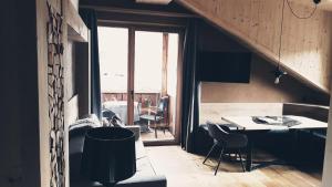 een kamer met een tafel en stoelen en een raam bij Naturhotel Sonnenhof in Chiusa