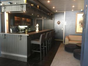 a bar in a restaurant with a counter and chairs at Havila Hotel Geiranger in Geiranger