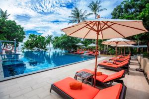 einen Pool mit Stühlen und Sonnenschirmen neben einem Pool in der Unterkunft New Star Beach Resort in Strand Chaweng Noi