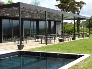 a pavilion with tables and chairs next to a pool at Château du Clair de Lune - Boutique Luxury Hotel in Biarritz
