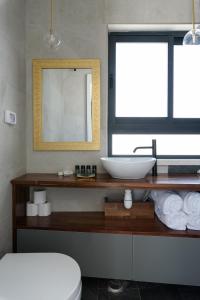 a bathroom with a sink and a mirror at The Roof - By Sea Land Suites in Tel Aviv