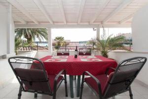 einen Tisch mit einem roten Tischtuch auf einer Terrasse in der Unterkunft Porto del Mar Medulin B & B in Medulin