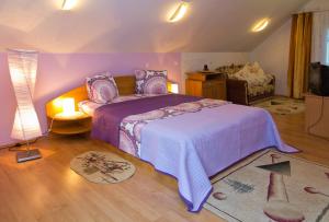 a bedroom with a bed with a purple comforter at Perla Balvanyos in Balvanyos