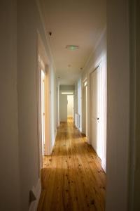 an empty hallway with wooden floors in an apartment at VisHostel in Viseu