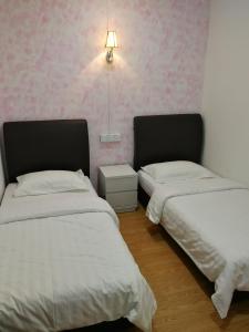 Coral Home 珊瑚之家 في سيمبورنا: سريرين في غرفة مع ورق جدران وردي