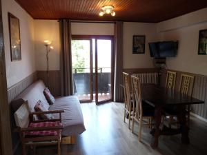 a living room with a table and a couch and a table and chairs at Chalet Le Bois Noir in Valdeblore