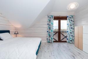 sypialnia z łóżkiem i oknem w obiekcie Przy Rozlewisku w Sarbinowie