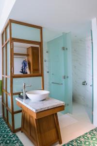 a bathroom with a sink and a glass shower at Vinh Hung Old Town Hotel in Hoi An
