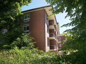 a red brick building with trees in front of it at Haus Roland- Whg 22 & 25 mit Schwimmbad und Sauna in Zinnowitz