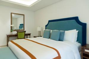 Rúm í herbergi á Al Najada Doha Hotel Apartments by Oaks