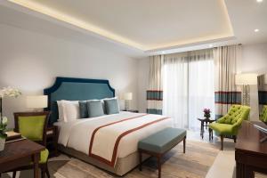 Rúm í herbergi á Al Najada Doha Hotel Apartments by Oaks