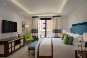 Rúm í herbergi á Al Najada Doha Hotel Apartments by Oaks