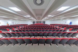 una sala conferenze vuota con sedie rosse di Casa per Ferie Sant'Anna a Matera