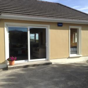 a building with a sliding glass door with a window at Ben Haven Self Catering Accommodation in Ballaghnatrillick