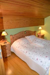 a bedroom with a large bed with a wooden ceiling at Les Loges du Lac - Appartement avec Terrasse in Gérardmer +4 photos