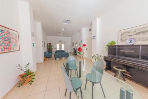 un corridoio con sedie e un pianoforte in una stanza di Casa per Ferie Sant'Anna a Matera