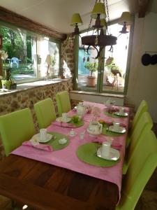 モントルーにあるLa Rose des Ventsのダイニングルームテーブル(ピンクのテーブルクロス、緑の椅子付)
