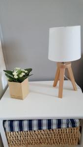 een witte tafel met een lamp en een plant erop bij Appartement entre ciel et mer - Vue éblouissante in Le Grau-dʼAgde