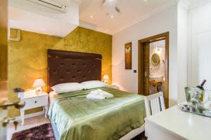 Bella Natka Bed and Breakfast في روفينج: غرفة نوم بسرير اخضر كبير في غرفة